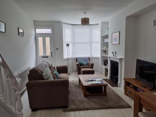 a living room with a couch and a coffee table at Just Beachy - 2 Bedroom Traditional cosy fisherman's cottage in Scarborough