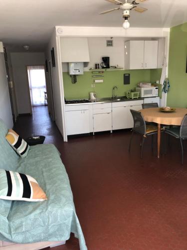 un salon et une cuisine avec un canapé et une table dans l'établissement Appartement F3 St Cyprien plage, à Saint-Cyprien