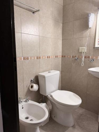 a bathroom with a white toilet and a sink at Cabañas Boulevard in Chascomús