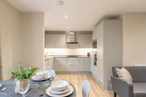 a kitchen and living room with a table and chairs at Maple Apartments - Stylish 1 Bed Apartment in Derby in Derby