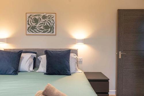 a bedroom with a bed with blue and white pillows at Maple Apartments - Stylish 1 Bed Apartment in Derby in Derby