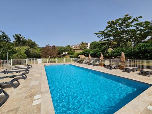 - une piscine avec des chaises longues et des chaises dans l'établissement Cardellini 10- vue mer-piscine en résidence, à Sari-Solenzara