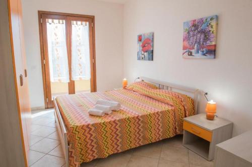a bedroom with a bed with two towels on it at Appartamento su due piani con vista mare in Castelsardo