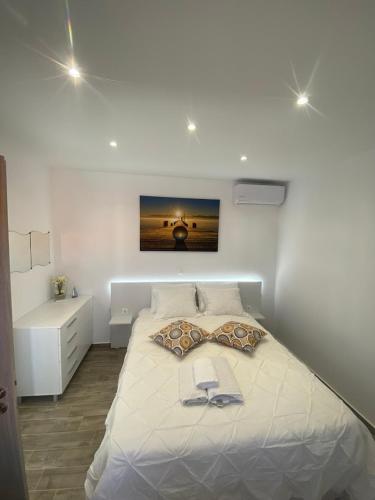 a bedroom with a large white bed with a book on it at Angelica Residence in Gennadi