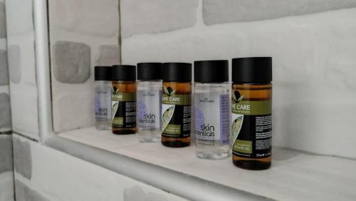 four bottles of spices sitting on a shelf in a bathroom at Angelica Residence in Gennadi