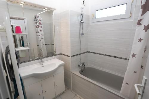 une salle de bain blanche avec un lavabo et une douche dans l'établissement St Cyprien appart 3etoiles avec belle terrasse, à Saint-Cyprien