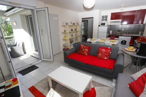 un salon avec un canapé et une cuisine dans l'établissement St Cyprien appart 3etoiles avec belle terrasse, à Saint-Cyprien