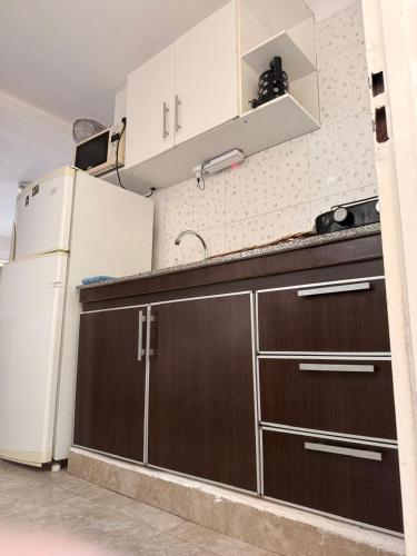 a kitchen with brown cabinets and a white refrigerator at Cabañas Boulevard in Chascomús
