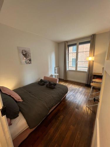 une chambre avec un grand lit et une grande fenêtre dans l'établissement Luxury Suite Saint-Germain - Notre-Dame, à Paris