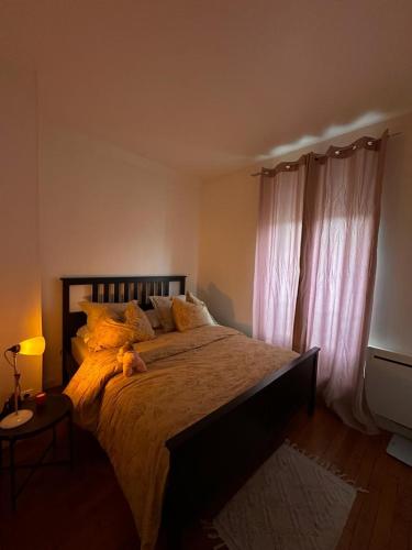 - une chambre dotée d'un grand lit avec un ours en peluche dans l'établissement Petit paradis, à Courbevoie