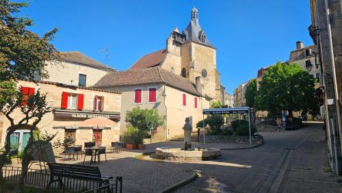 ein Gebäude mit einem Uhrturm auf einer Straße in der Unterkunft Le "Chic en Ville" Centre historique, climatisé, wifi, Parking sous-sol inclus in Bergerac