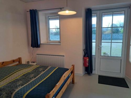 une chambre avec un lit et une grande fenêtre dans l'établissement Le Lerry aux Pierres Bleues, à Surtainville
