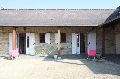 deux chaises roses assises à l'extérieur d'une maison en briques dans l'établissement Le Lerry aux Pierres Bleues, à Surtainville