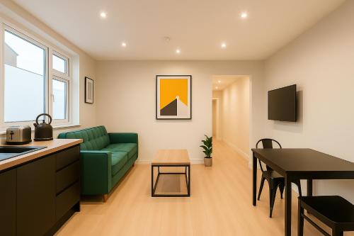a living room with a green couch and a table at Modern Central Apartment + King Size Bed + Garden in Cardiff