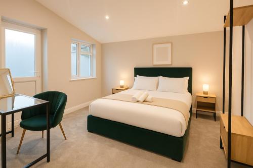 a bedroom with a bed and a desk and a chair at Modern Central Apartment + King Size Bed + Garden in Cardiff