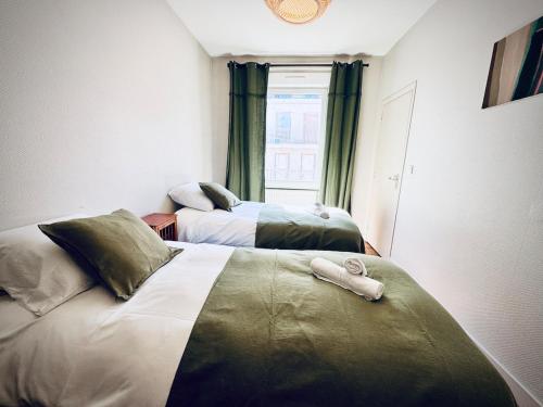 a hotel room with two beds with towels on them at Le JaKadi, Townhouse, Rennes city center in Rennes