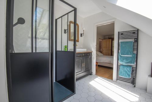 Un baño con ducha con lavabo y espejo. en l'élégante, en Savennières