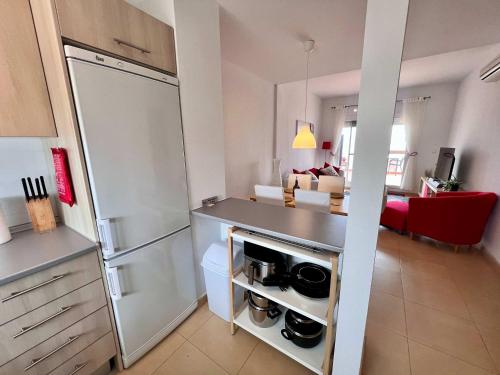 a kitchen with a refrigerator and a living room at CONDADO DE ALHAMA PENTHOUSE 8 SV33 in Alhama de Murcia