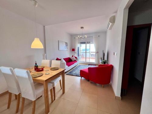 a dining room and living room with a table and chairs at CONDADO DE ALHAMA PENTHOUSE 8 SV33 in Alhama de Murcia