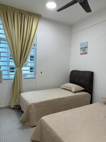a bedroom with two beds and a window at Sky9Haven Homestay in Ipoh