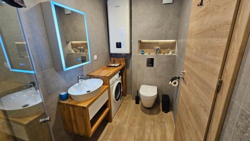 łazienka z umywalką, toaletą i lustrem w obiekcie Luxury 2 Room Flat Free Parking, Pool and WiFi w Warnie
