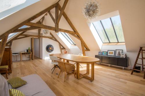 - un salon avec une table en bois et quelques fenêtres dans l'établissement l'élégante, à Savennières