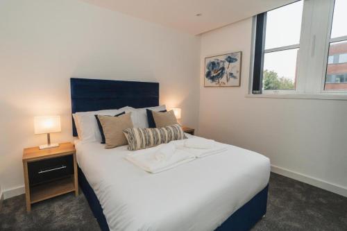 a bedroom with a large white bed and a window at Thornhill House Apartments by VICHY in Wakefield