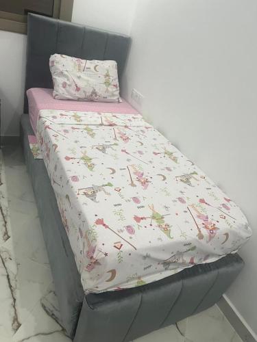 a bed with a bed frame with a floral bedsheet at Appartement à saidia in Saidia 