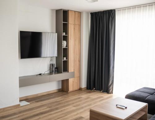 a living room with a television on a wall at ТОП Апартаменти в Панорама Парк in Plovdiv