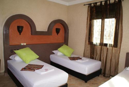 a room with two beds and a window at Riad Les Jardins de Tafraoute in Foum Mharech
