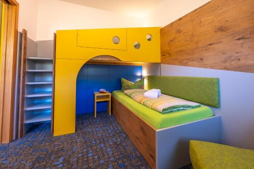 a childrens bedroom with a yellow bunk bed at Familotel Mein Krug in Warmensteinach