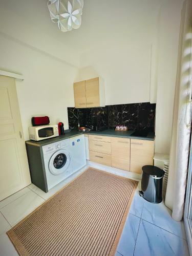 une cuisine avec un lave-linge et un micro-ondes dans l'établissement Lovely Riviera Apartment, à Nice