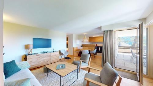 a living room with a couch and a table at Setaria für 5 Personen Haus Barlangia-Lenzerheide in Valbella