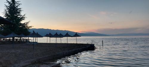 a group of umbrellas on a beach in the water at Villa Nathanael Cozy Rooms with Balcony in Pogradec