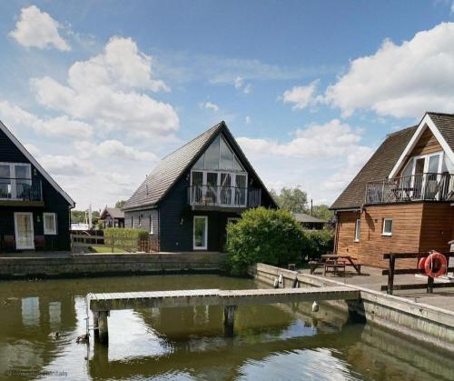 a house next to a body of water at Wherrymere in Horning