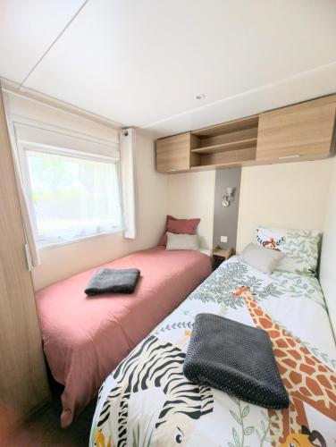 une petite chambre avec deux lits et une fenêtre dans l'établissement gite la campagne doré, à Tour-en-Bessin