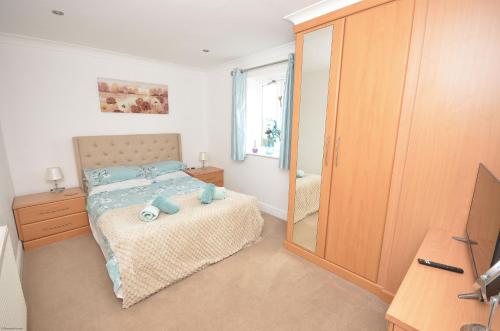 a bedroom with a bed and a mirror at Wherrymere in Horning