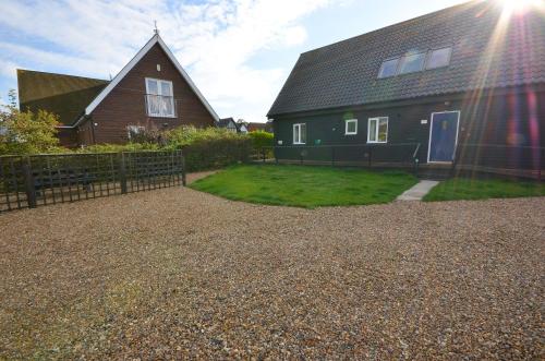 a house with a fence in front of a yard at Wherrymere in Horning