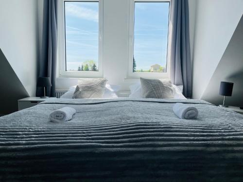 a bedroom with a large bed with two windows at Villa Appartements Syke in Syke