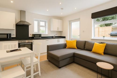 a living room with a couch and a kitchen at 6 Person Apartment in City Centre in Cardiff