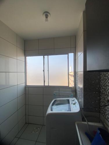 a bathroom with a sink and a window in it at Goiás Brasília Confort in Valparaíso de Goiás