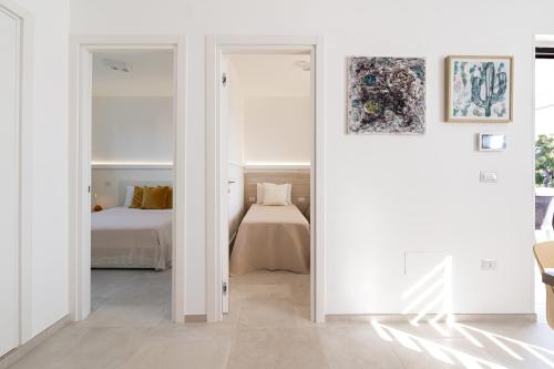 a white room with a bed and a door leading to a bedroom at La casa di Connie a 250mt dalla spiaggia in Torre Santa Sabina