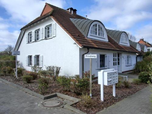 ein weißes Haus mit einem Schild davor in der Unterkunft Achterwasserblick in Zempin