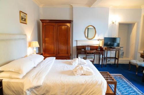 a bedroom with a large white bed and a desk at Castle Grove Country House Hotel in Letterkenny