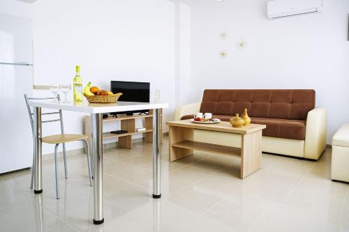 ein Wohnzimmer mit Tisch und Couch in der Unterkunft Sunset Sea View Cottage in Chalkidiki's Oasis in Metókhion Patriotikón