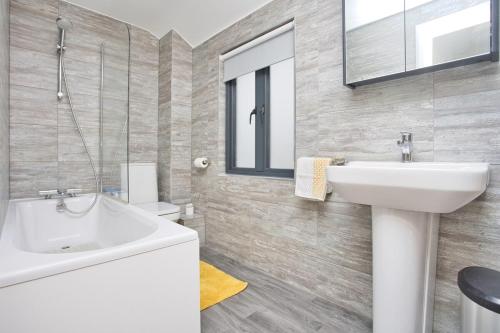 a white bathroom with a sink and a mirror at Pebble Beach by the Sea in Deal