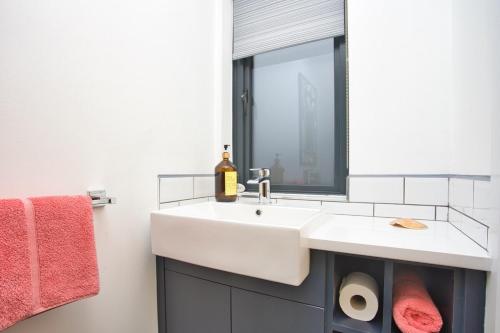 a bathroom with a white sink and a mirror at Pebble Beach by the Sea in Deal