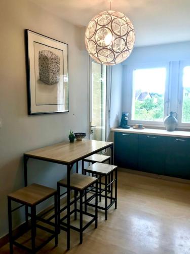 une salle à manger avec une table, des chaises et un éclairage dans l'établissement Villa Eléno, au cœur de la région des lacs du Jura, à Meussia