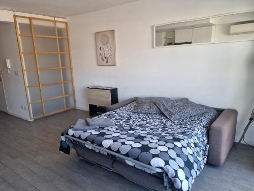 une chambre avec un lit avec une couette noire et blanche dans l'établissement Agréable appartement plages et hypercentre, à Antibes