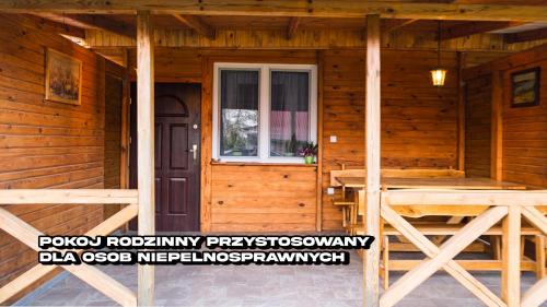 a wooden cabin with a porch and a window at Agroturystyka Nielisz Zamość - Kwatery przy Skansenie in Nielisz